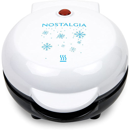 Gaufrier blanc fermé Nostalgia MWFSNWFLK5WH avec motif extérieur de flocon de neige bleu ; l’image ne montre pas la grille de cuisson.